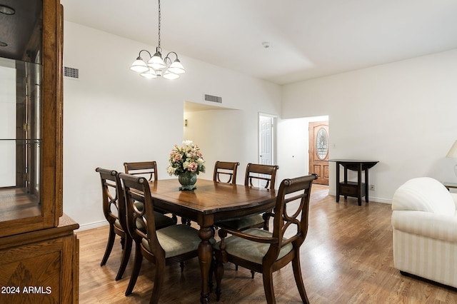 dining area with hardwood / wood-style flooring and a chandelier