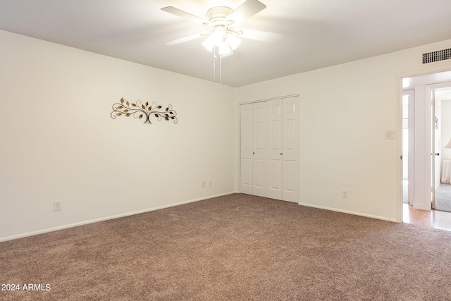 carpeted spare room featuring ceiling fan