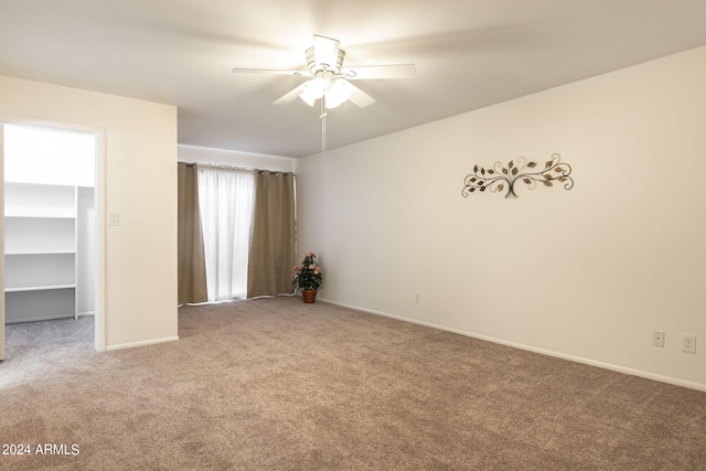 unfurnished bedroom with ceiling fan, carpet, and a spacious closet