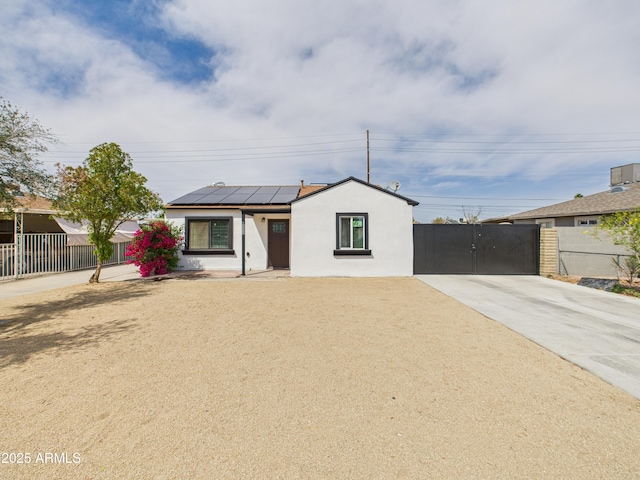 2628 W Marshall Ave, Phoenix, AZ 85017 - view of front of house featuring concrete driveway, solar panels, fence, and stucco siding