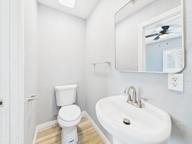 2628 W Marshall Ave, Phoenix, AZ 85017 - half bath featuring baseboards, toilet, ceiling fan, a sink, and wood finished floors