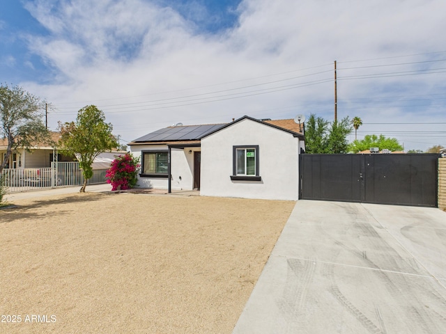 2628 W Marshall Ave, Phoenix, AZ 85017 - view of front facade with stucco siding, a gate, driveway, solar panels, and fence