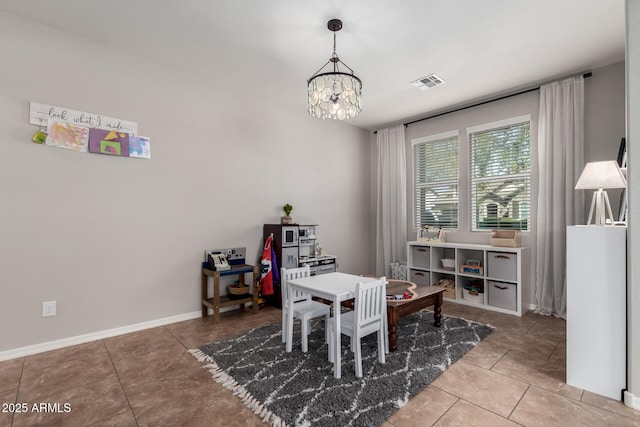 tiled dining space featuring baseboards, visible vents, and a notable chandelier