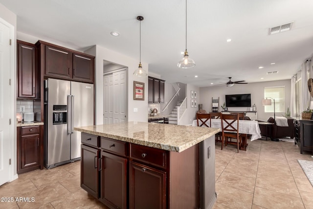 kitchen featuring high quality fridge, visible vents, open floor plan, decorative backsplash, and decorative light fixtures