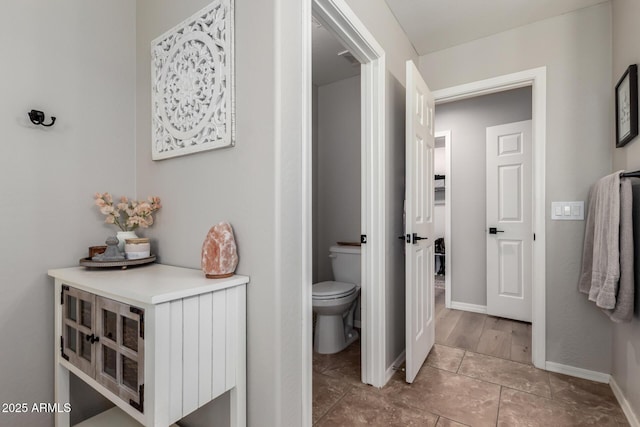 bathroom with toilet and baseboards