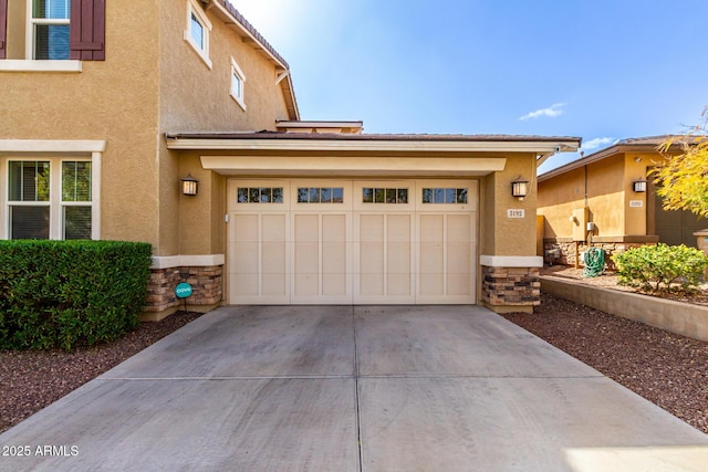 view of front of home featuring driveway, stone siding, and stucco siding