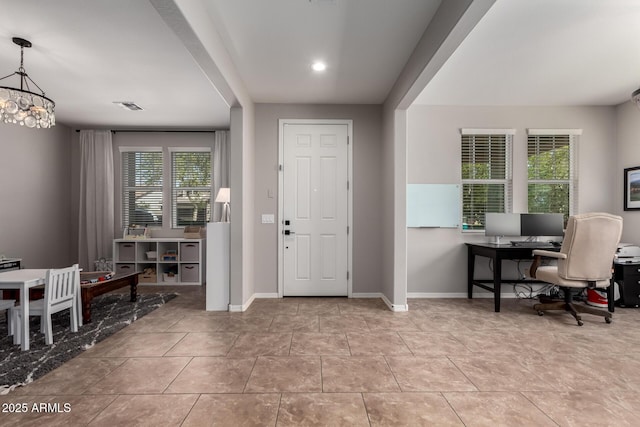 foyer featuring a notable chandelier, baseboards, visible vents, and tile patterned flooring