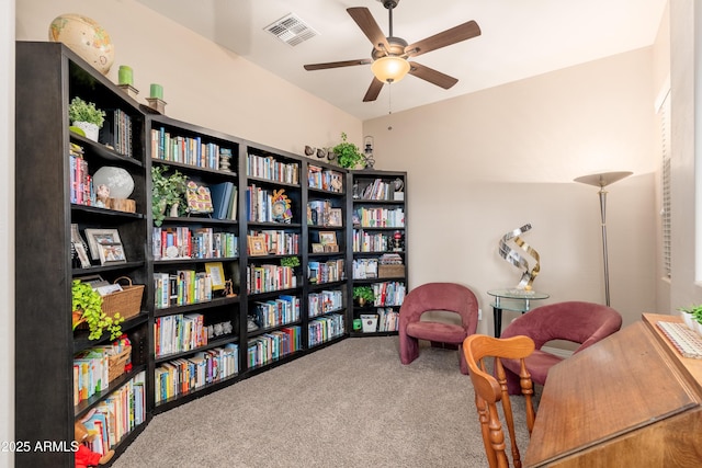living area with visible vents, carpet, and ceiling fan