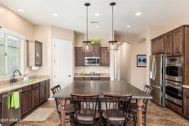 kitchen featuring visible vents, a sink, dark brown cabinets, and stainless steel appliances