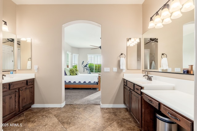 ensuite bathroom with baseboards, connected bathroom, and ceiling fan