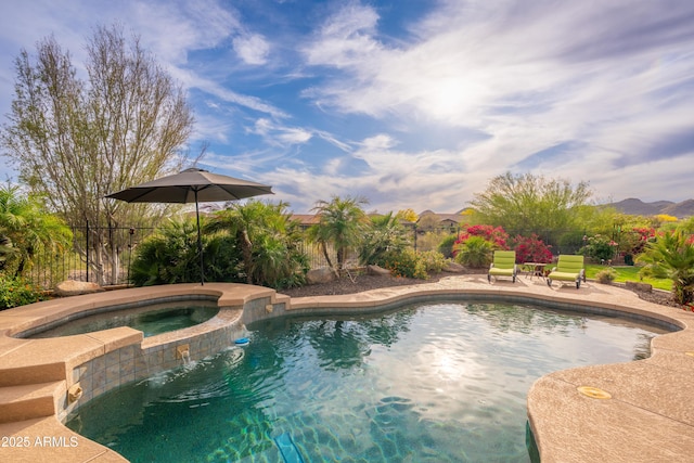 view of pool with a patio, a fenced backyard, and a pool with connected hot tub