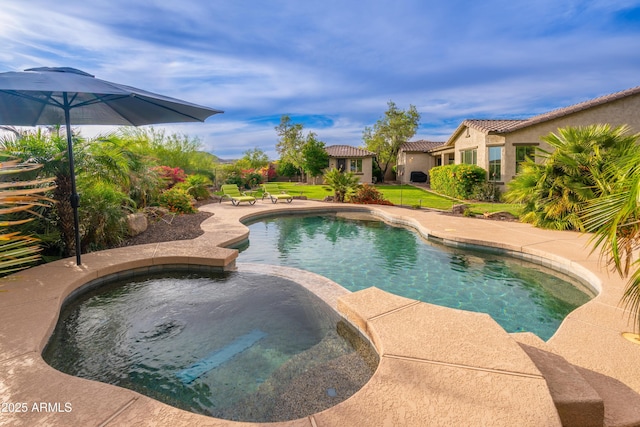 view of swimming pool with a patio and a pool with connected hot tub