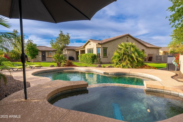 view of swimming pool featuring a lawn, a patio, and a pool with connected hot tub