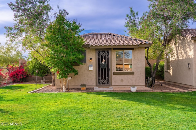 exterior space featuring a tiled roof, stucco siding, a yard, and fence