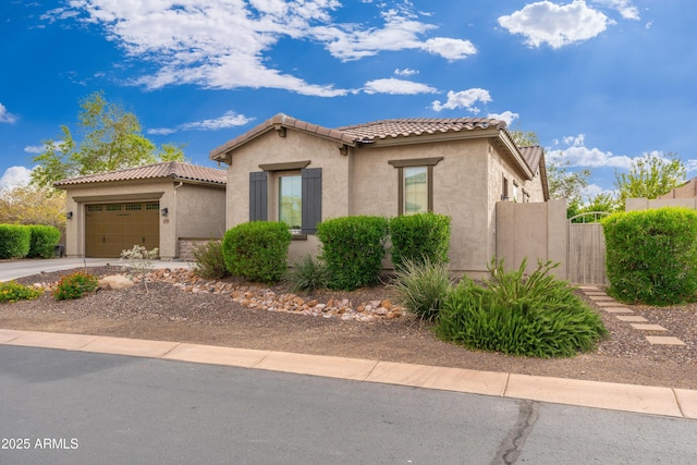 mediterranean / spanish-style house featuring a garage, stucco siding, driveway, and a tile roof