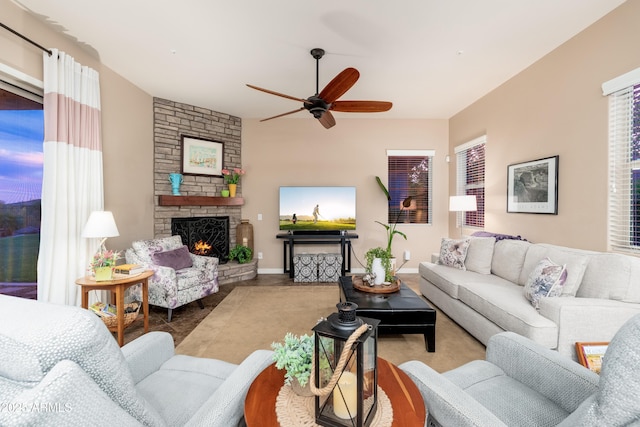 living area featuring ceiling fan and a fireplace