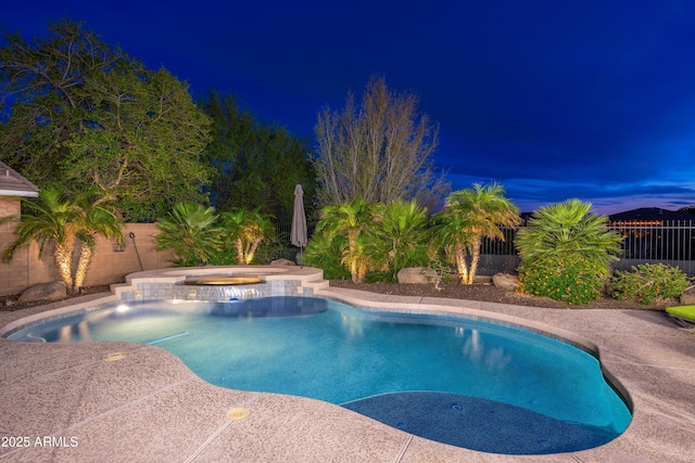 view of pool with a fenced backyard and a pool with connected hot tub
