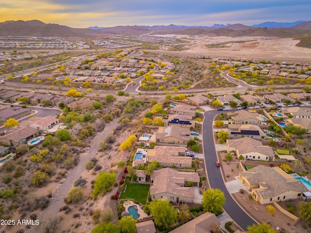aerial view at dusk featuring a residential view and a mountain view
