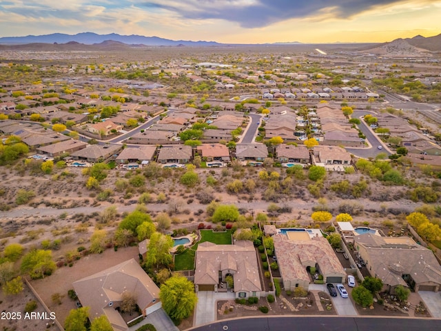 aerial view at dusk featuring a residential view and a mountain view