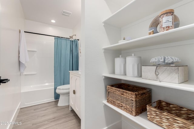 bathroom with toilet, recessed lighting, wood finished floors, and shower / bathtub combination with curtain