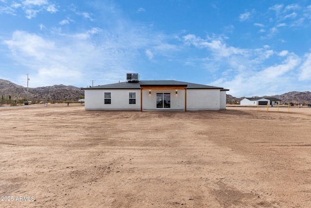 rear view of property with central AC unit and a mountain view