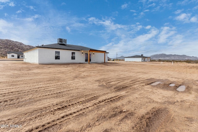 back of house with central AC unit and a mountain view
