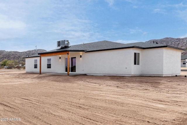 rear view of house with a mountain view, central AC, and a patio area