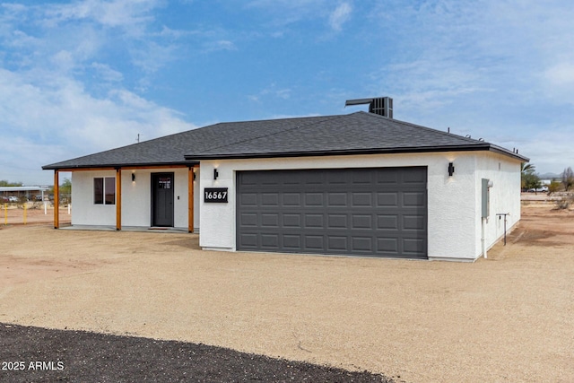 view of front facade featuring driveway, stucco siding, a garage, and roof with shingles