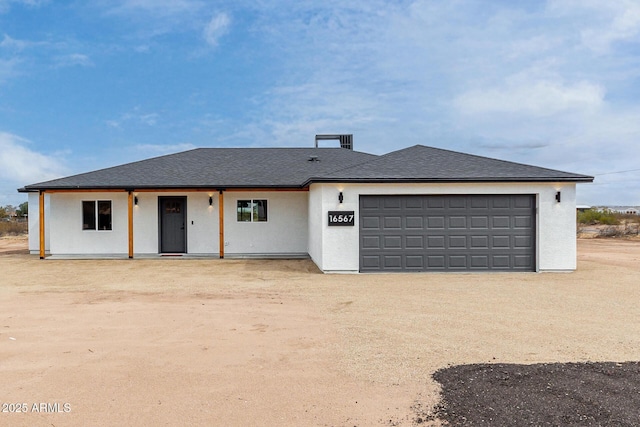 view of front facade with driveway, a garage, and stucco siding