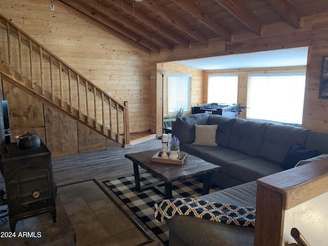 living room featuring lofted ceiling, a wood stove, wooden walls, wood ceiling, and dark hardwood / wood-style flooring