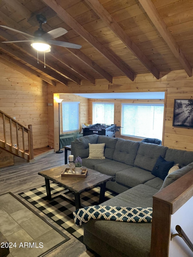 living room featuring wooden walls, ceiling fan, vaulted ceiling with beams, and wood ceiling