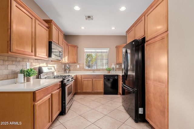 kitchen featuring light tile patterned flooring, sink, decorative backsplash, and black appliances