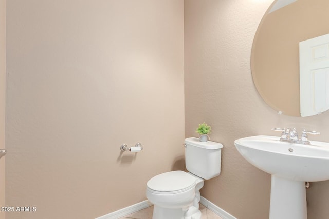 bathroom with sink, toilet, and tile patterned flooring