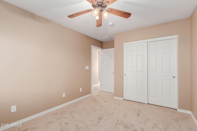 unfurnished bedroom with light colored carpet, a closet, and ceiling fan