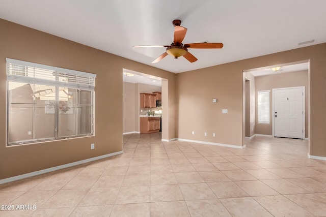 tiled spare room featuring ceiling fan