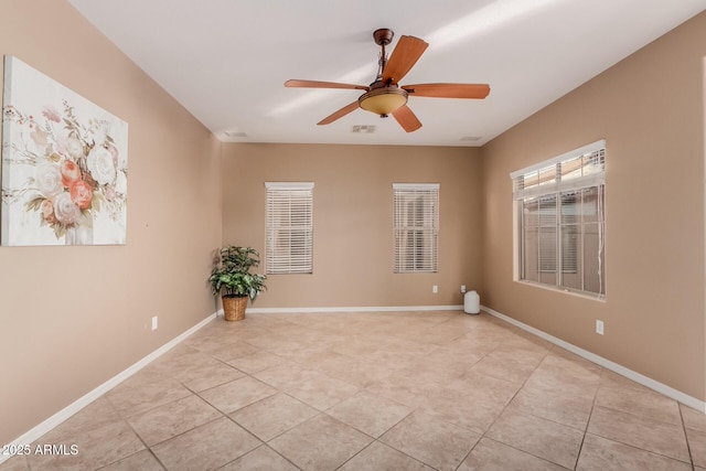 tiled spare room with ceiling fan