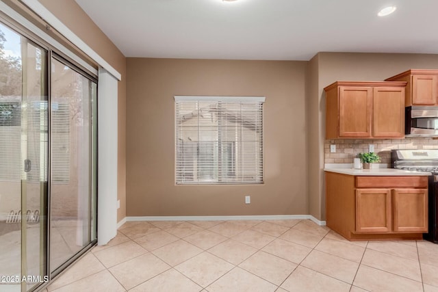 kitchen featuring stainless steel appliances, light tile patterned floors, and decorative backsplash