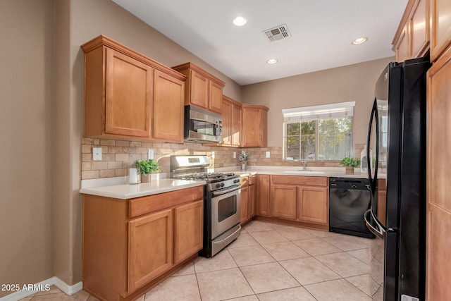 kitchen with light tile patterned flooring, sink, decorative backsplash, and black appliances