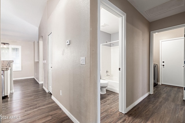 corridor with lofted ceiling and dark wood-type flooring