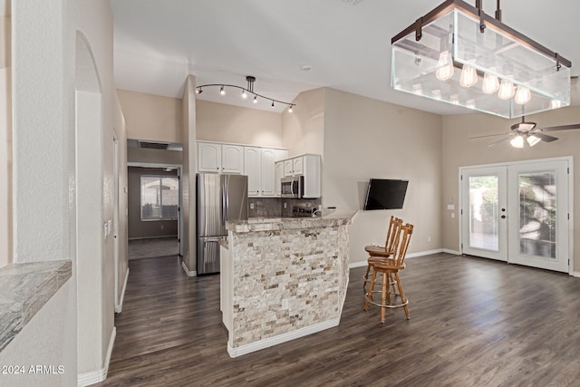 kitchen featuring kitchen peninsula, white cabinetry, dark hardwood / wood-style floors, and appliances with stainless steel finishes