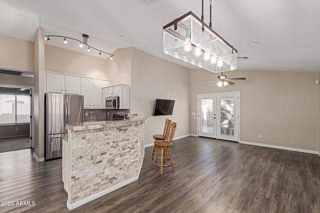 kitchen with stainless steel appliances, kitchen peninsula, white cabinets, and a healthy amount of sunlight