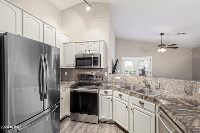 kitchen featuring white cabinetry, sink, light hardwood / wood-style floors, lofted ceiling, and appliances with stainless steel finishes