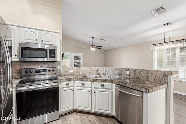 kitchen with white cabinetry, sink, stainless steel appliances, light hardwood / wood-style flooring, and kitchen peninsula