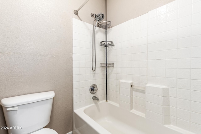 bathroom featuring tiled shower / bath combo and toilet