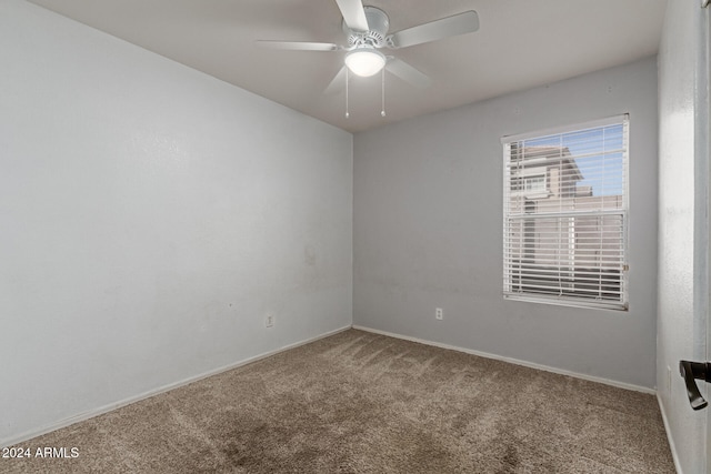 carpeted spare room with ceiling fan