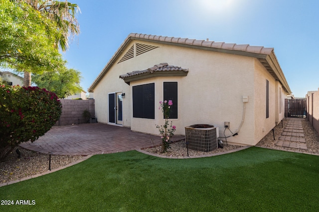 rear view of property with a patio area, a yard, and cooling unit