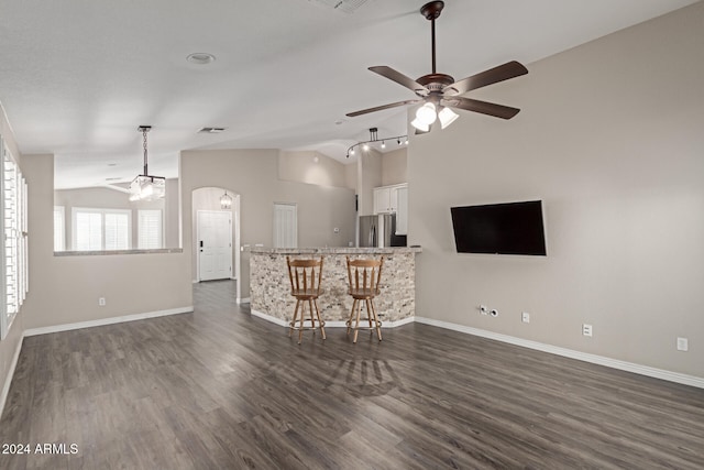 unfurnished living room featuring ceiling fan, dark hardwood / wood-style flooring, and lofted ceiling