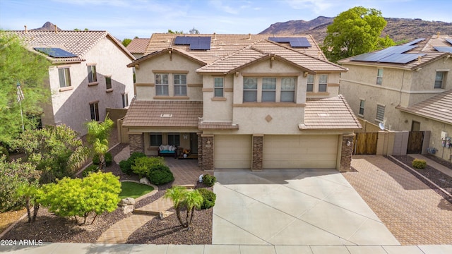 multi unit property featuring solar panels, a mountain view, and a garage