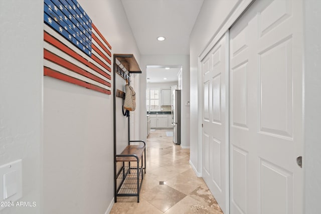 hallway with recessed lighting and baseboards