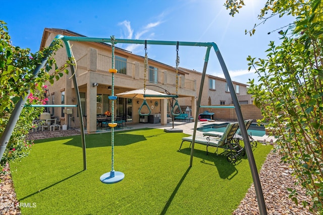 exterior space with a playground, a patio, a balcony, and stucco siding